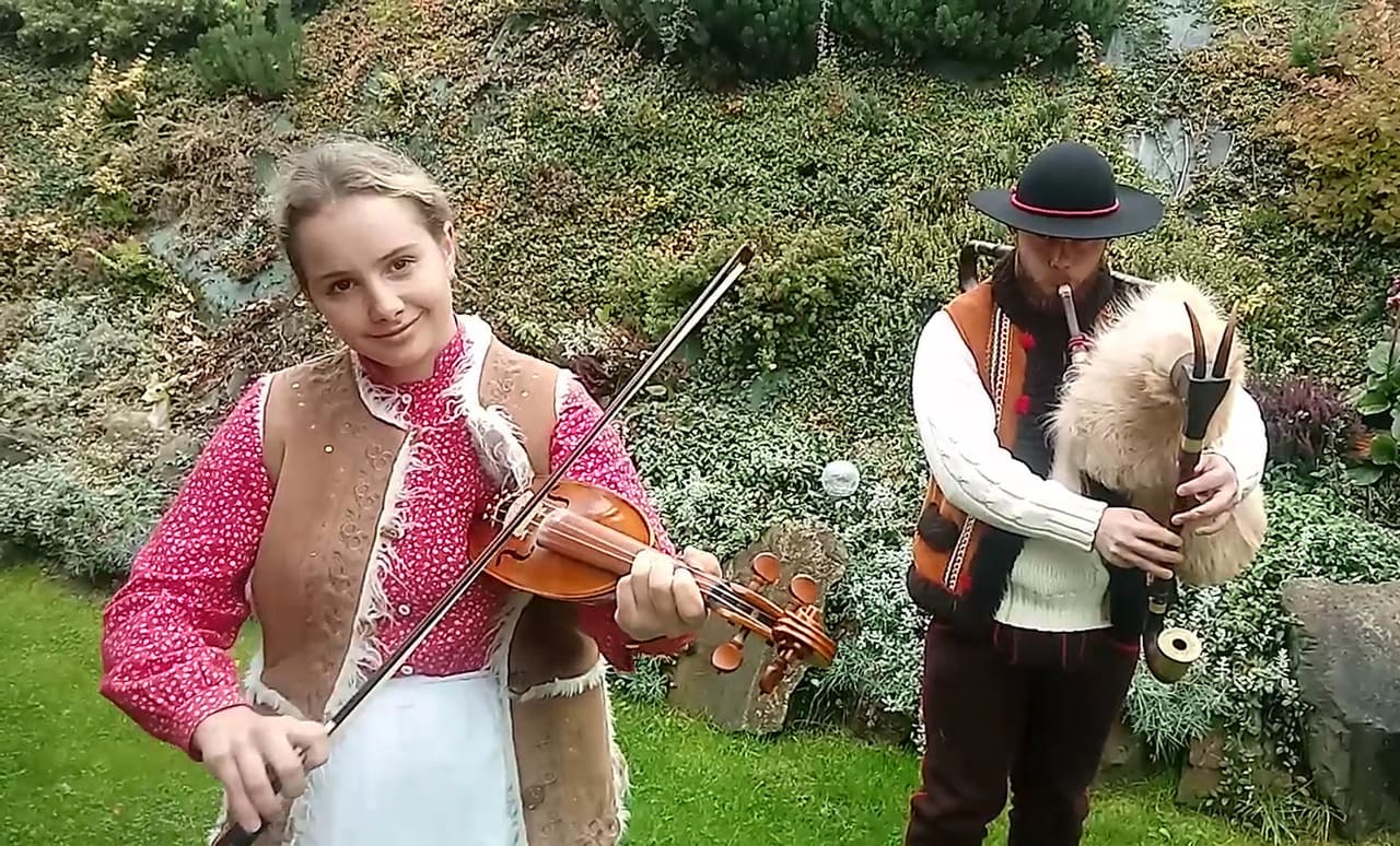 Góralka ze skrzypcami i góral z dudami - grają na instrumentach.